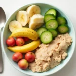 Repas équilibré avec purée de légumes, morceaux de poulet et fruits pour bébé de 8 mois